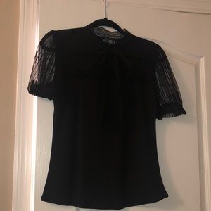 Dressy black top with mesh sleeves and chest.